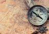 Old compass on a vintage map background
