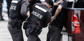 Police officers arresting a handcuffed person