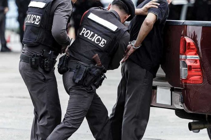 Police officers arresting a handcuffed person