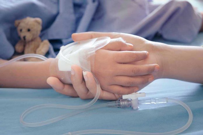 1168304533 Childs hand with IV, held by adult.