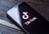 Phone screen showing TikTok logo and app.