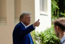 Man in suit giving thumbs up.