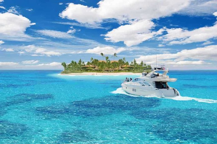 shutterstock_69458212.jpg A luxury yacht cruising in clear blue waters near a tropical island