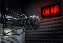 Microphone in soundproof studio with On Air sign.