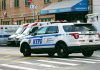 Police car and ambulances outside emergency room entrance.