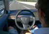 Man using autopilot mode in a Tesla car.