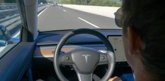 Man using autopilot mode in a Tesla car.