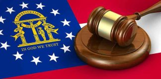 Georgia flag and judges gavel on wooden base.