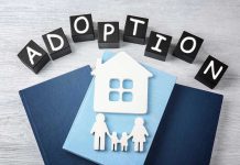 Adoption blocks, books, house, and family paper cutouts.