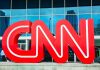 Large red CNN logo in front of a glass building