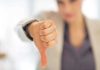 Businesswoman showing a thumbs down gesture in an office setting