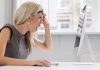A woman with blonde hair showing a surprised expression while looking at a computer