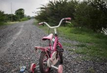 Texas Couple Vanishes — Child LEFT STRANDED Pink childrens bike with training wheels on gravel path.