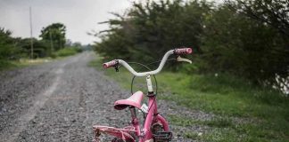 Texas Couple Vanishes — Child LEFT STRANDED Pink childrens bike with training wheels on gravel path.