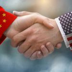 NEW US-China Trade Pact Unleashes Market Mayhem Chinese and American flag sleeves shaking hands.