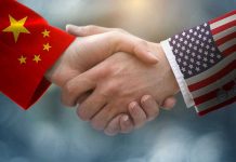 Chinese and American flag sleeves shaking hands.