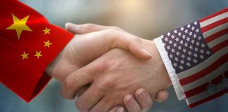 NEW US-China Trade Pact Unleashes Market Mayhem Chinese and American flag sleeves shaking hands.