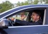 Man yelling inside a car, looking frustrated.