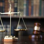 Scales of justice with gavel and books.