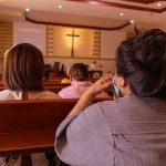 Mayor’s SHOCKING Suicide Attempt After Church Theft People sitting in church pews during service.