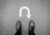 Shocking NEW Data Exposes Shutdown Blame Flip Feet in black shoes facing U-turn road marking.