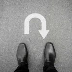 Shocking NEW Data Exposes Shutdown Blame Flip Feet in black shoes facing U-turn road marking.