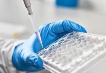 SHOCKING Discovery — Blood Reveals Invisible Cancers Gloved hand pipetting liquid into a tray.