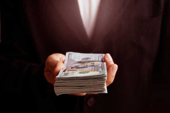 71912373 Hand holding a stack of hundred-dollar bills.