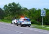 Roadside Dangers Exposed — Officer Killed in Action Police car pulling over a white car