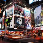 Vibrant night scene of Times Square filled with theater advertisements and neon lights