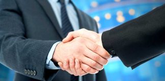 Two business professionals shaking hands in a corporate setting