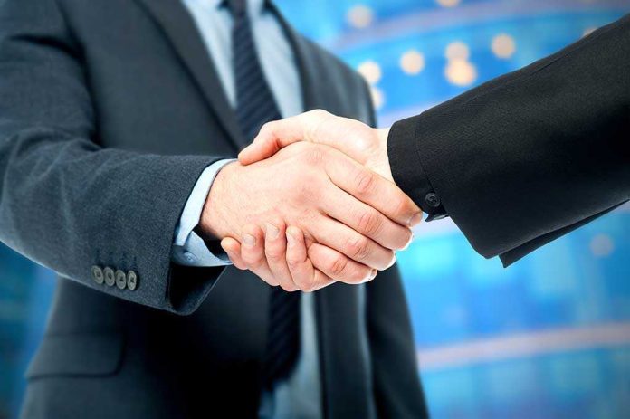 Two business professionals shaking hands in a corporate setting