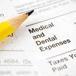 Close-up of tax document with medical and dental expenses section and a yellow pencil