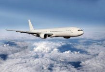 Pilot INJURED in Shocking Mid-Air Collision A white airplane flying above fluffy clouds in a blue sky