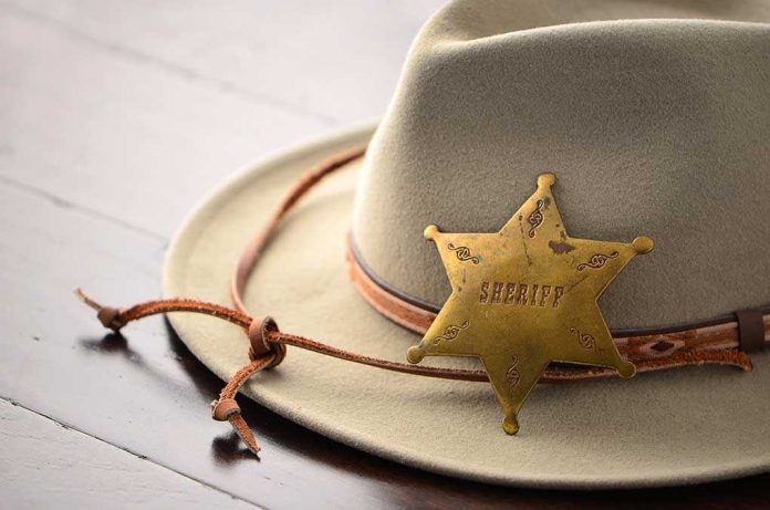 shutterstock_210860356.jpg A sheriffs hat with a vintage badge resting on a wooden surface