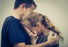A couple embracing, with one partner comforting the other who is in distress