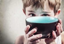 Democrats Accused of Hunger Games Tactics A child with a serious expression holding a bowl close to their face