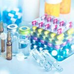 Vials and blister packs of pills on table