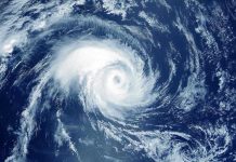 Shocking Insurance Abandonment Leaves Homeowners Stranded Satellite image of a swirling hurricane over ocean.