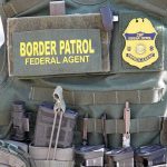Federal Agents DETAIN Workers – Town ERUPTS Border Patrol vest with gear and communication equipment.