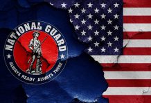 White House Shooting Sparks MORE Guard Deployment National Guard logo over a distressed American flag.