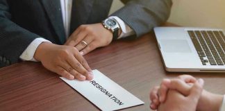 Handing in a resignation letter across a table.