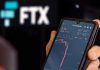Crypto’s $1 Trillion Wipeout—Wall Street Fled First Hand holding phone with FTX trading app.