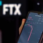 Hand holding phone with FTX trading app.