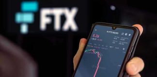 Hand holding phone with FTX trading app.