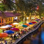 Wannabe Influencer STEALS Restaurant Meals—Judge FREES Her Outdoor riverside restaurant with colorful umbrellas and evening lights.