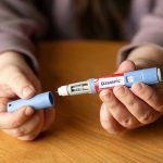 SCANDAL: Ozempic’s Dark Side Ignites Legal War Hands holding an Ozempic injection pen.