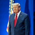 Border Crackdown — BILLIONS Vanish Overnight Man in suit next to American flag.