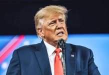 Trump Speech DOCTORED — BBC Caught Red-Handed Man in suit speaking at a microphone.