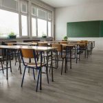 Shocking School Cover-Up Exposed Empty classroom with desks, chairs, windows, and chalkboard.